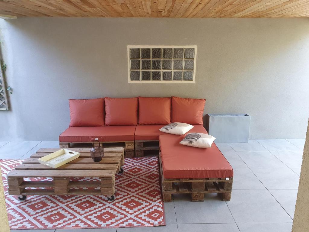 a living room with a red couch and a table at La terrasse du romarin in Gorges