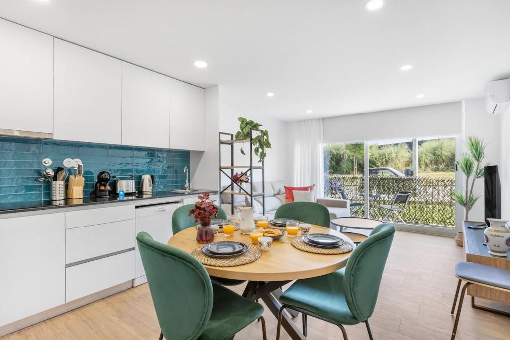 a kitchen and dining room with a table and chairs at Sunny Stays Espinho | Balcony & Pool in Espinho