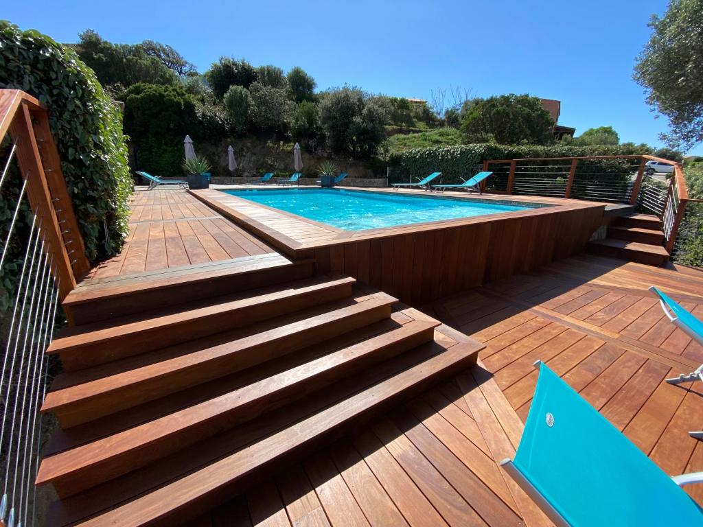 a swimming pool with stairs next to a wooden deck at Casa Léna in Propriano