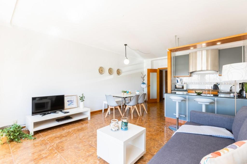 a living room with a couch and a kitchen at Aguda Beach Apartment in Arcozelo