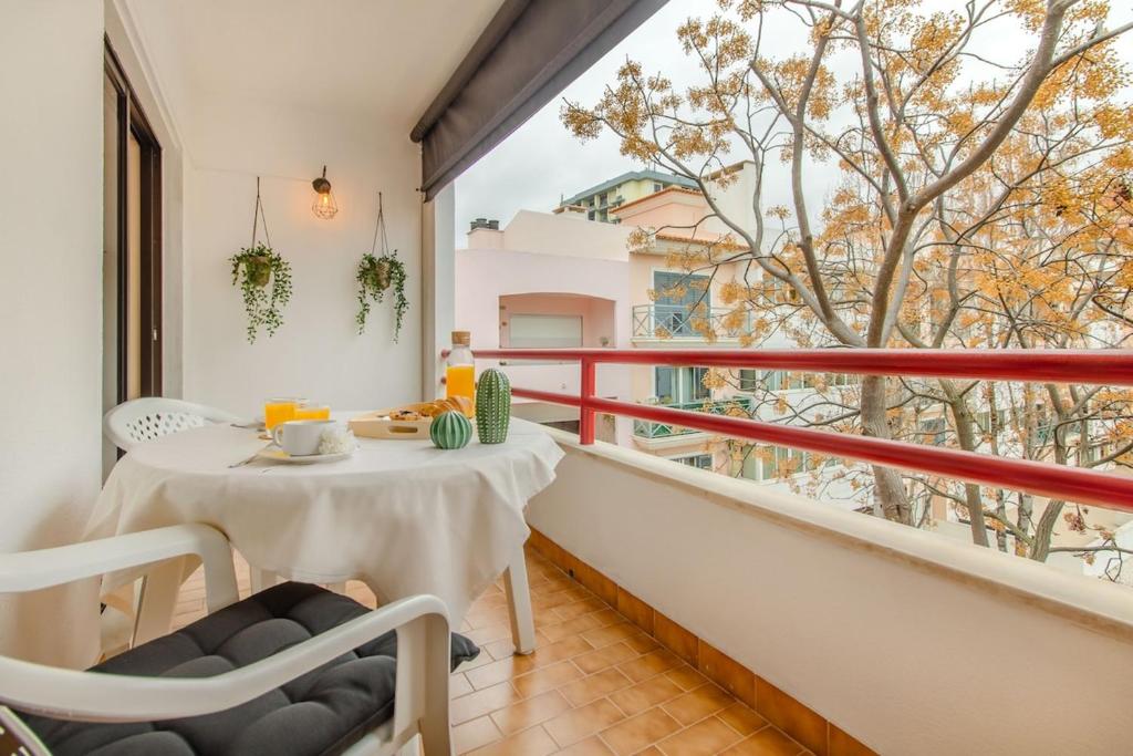 a balcony with a table and chairs and a large window at Cantinho em Cascais, Spacious 3BR with Balconies in Cascais