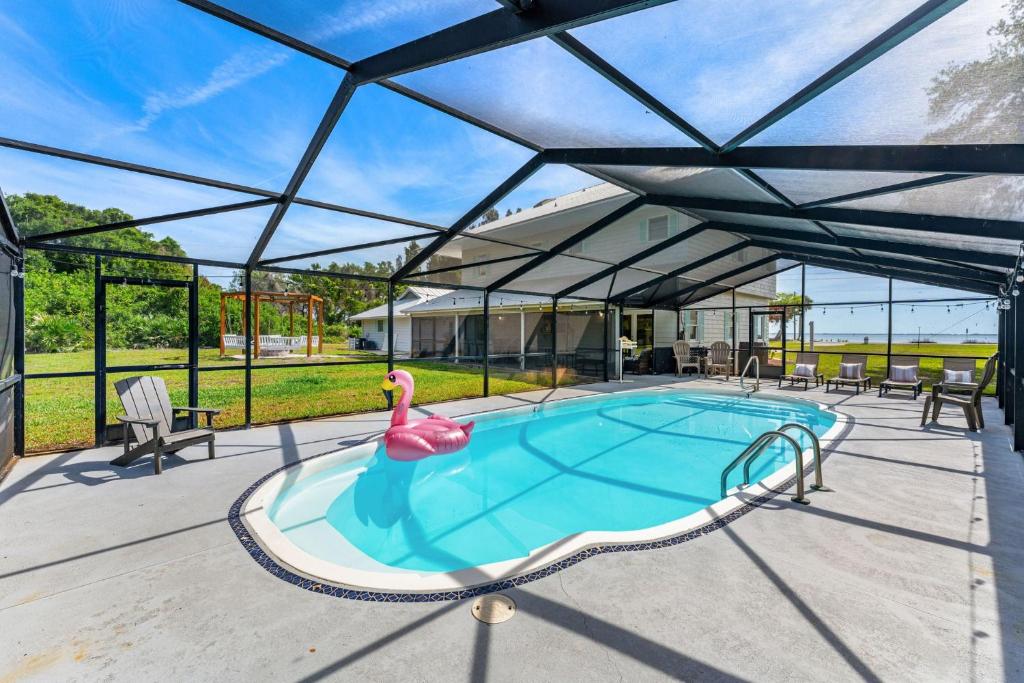 a swimming pool with a pink flamingo in a house at 5665 S. Tropical Trail in Merritt Island