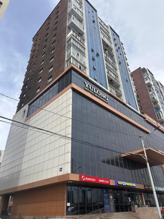 a tall building with a sign on the side of it at Comfy apartment near central train station in Ulaanbaatar