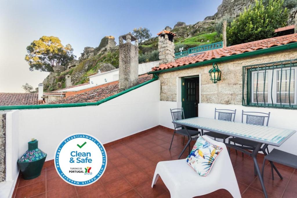 a patio with a table and chairs on a house at Casa Mont'Santo with Balcony & Terrace in Monsanto