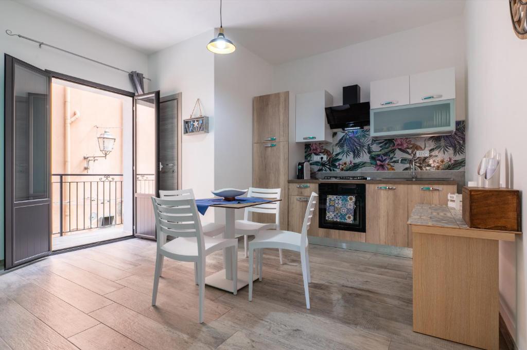 a kitchen and dining room with a table and chairs at Perla Marina Rooms in Realmonte
