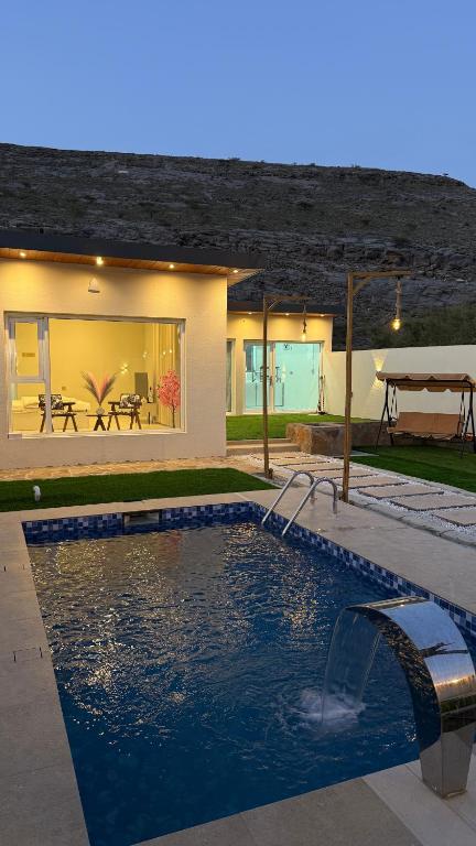 a swimming pool in front of a house at Reef ALjabal Rest in Minthār