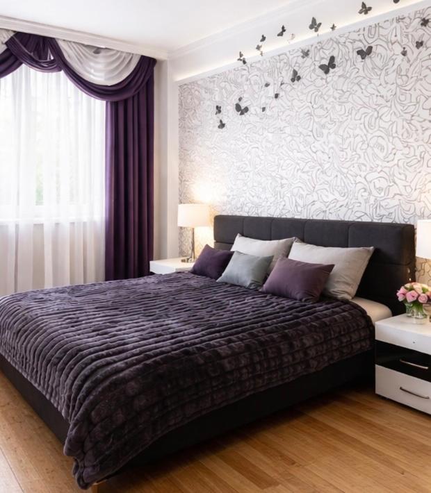 a bedroom with a large bed with a purple comforter at Two bedroom in Park Zone in Kamianets-Podilskyi