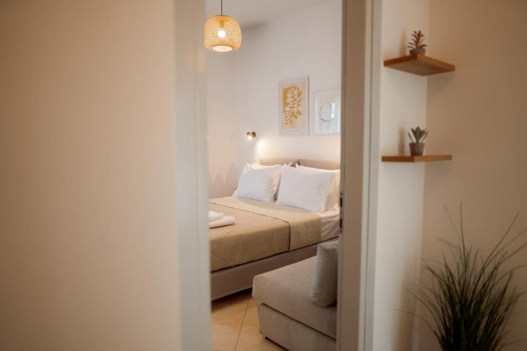 a small bedroom with a bed and a couch at White Nest Rooms in Potos