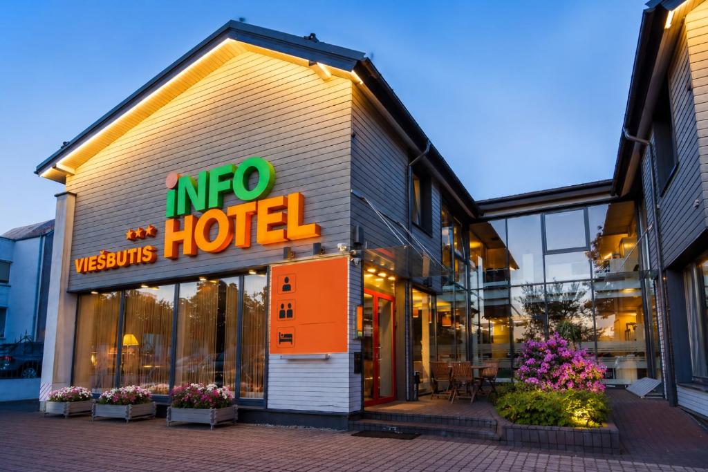 a hotel with a sign on the front of it at Info Hotel in Palanga