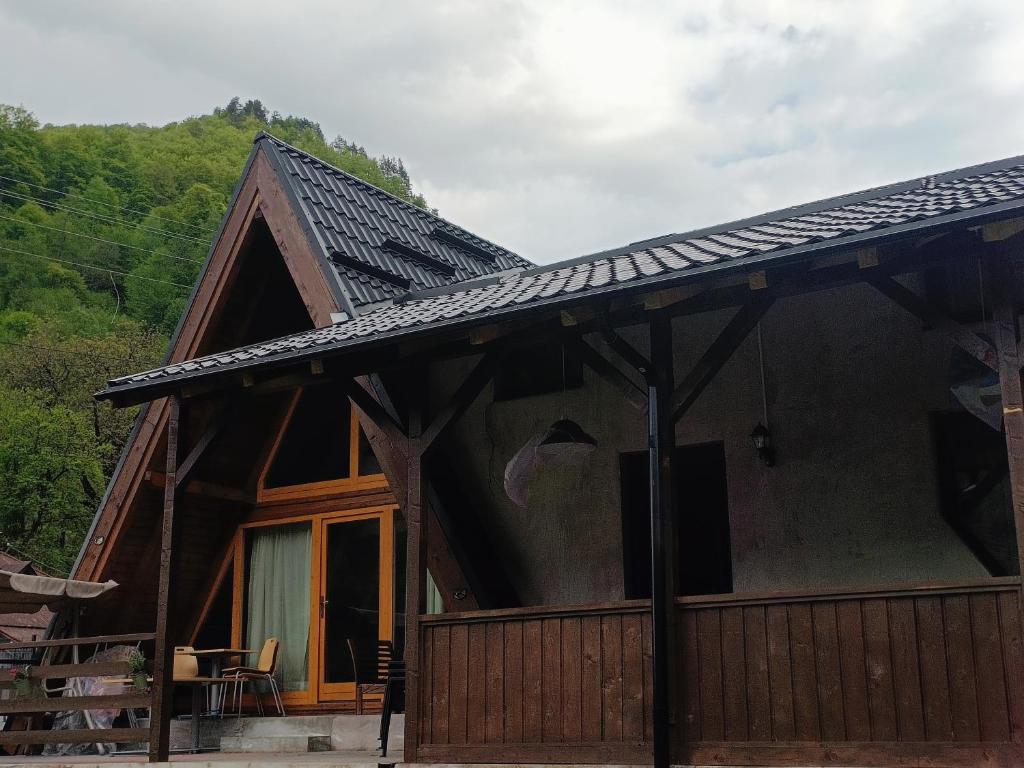 a log cabin with a gambrel roof at Lotru Relax Chalet in Malaia