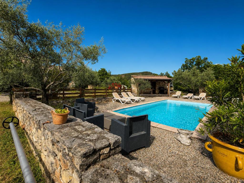 a pool in a yard with chairs and a house at Chez Polo Villa avec piscine et pool house privé in Vallon-Pont-dʼArc