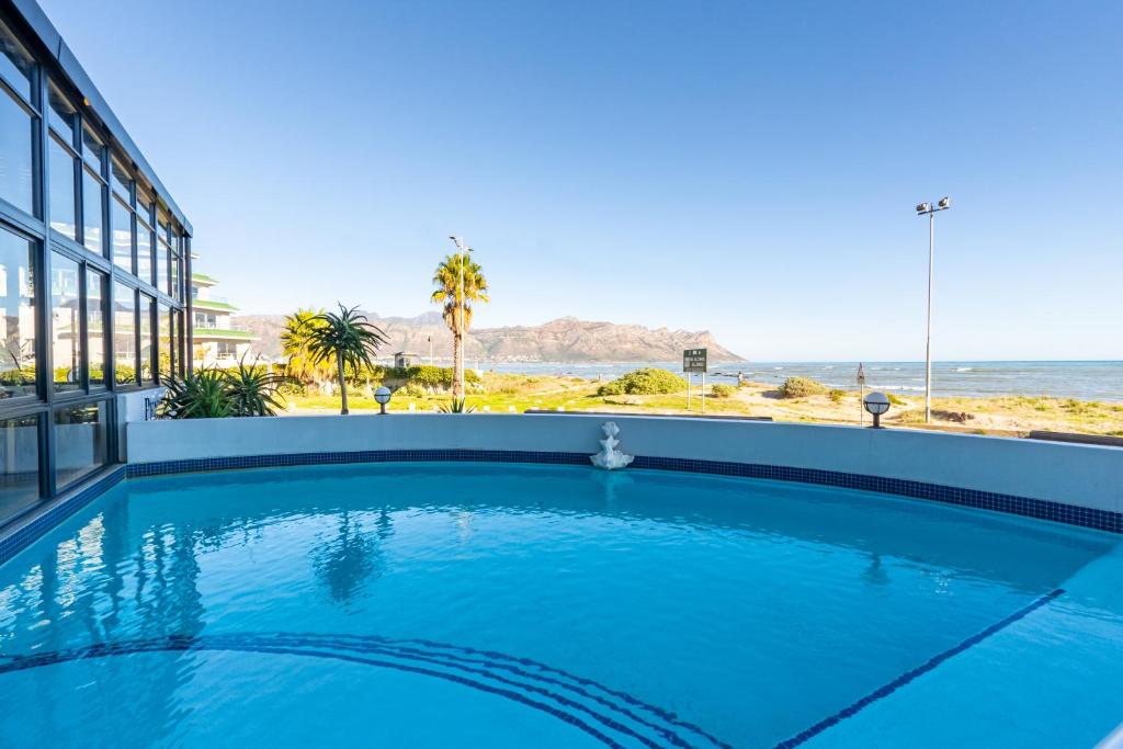 a swimming pool with a view of the ocean at 419 Ocean Breeze in Cape Town