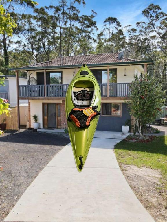 a yellow kayak on display in front of a house at Tranquil Waters Edge Escape in Sanctuary Point