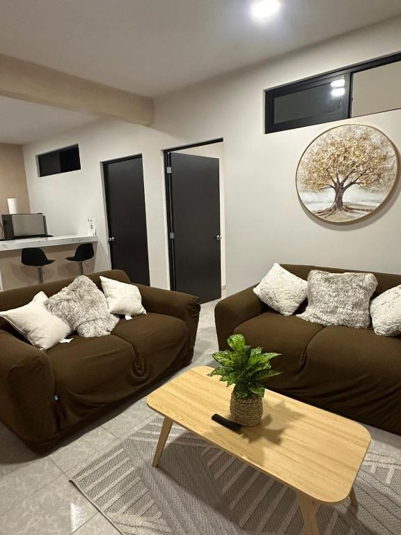 a living room with two brown couches and a table at Departamento en el CENTRO DE XALAPA 2habitaciones GARAGE INCLUIDO in Xalapa