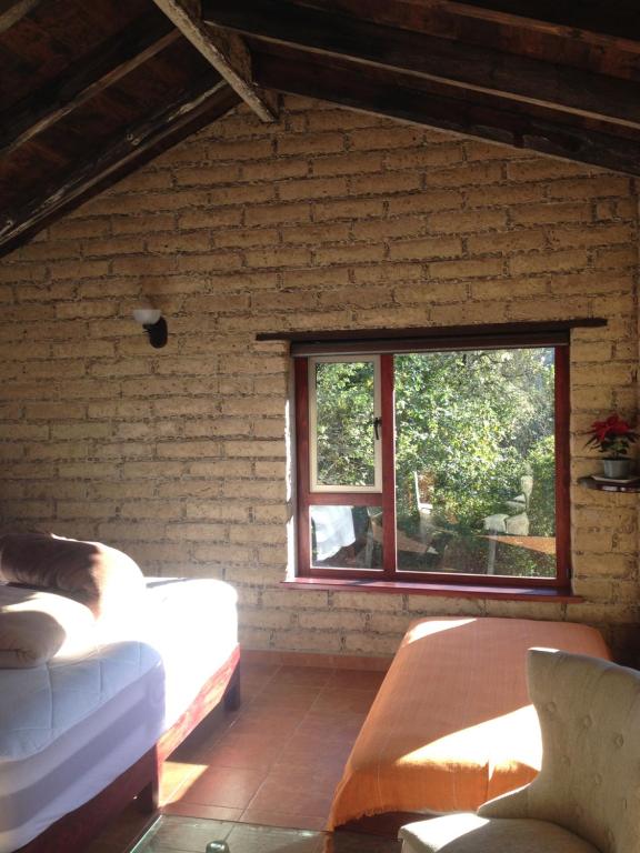 a living room with two beds and a window at Cabañas Hojarasca in Mineral del Chico