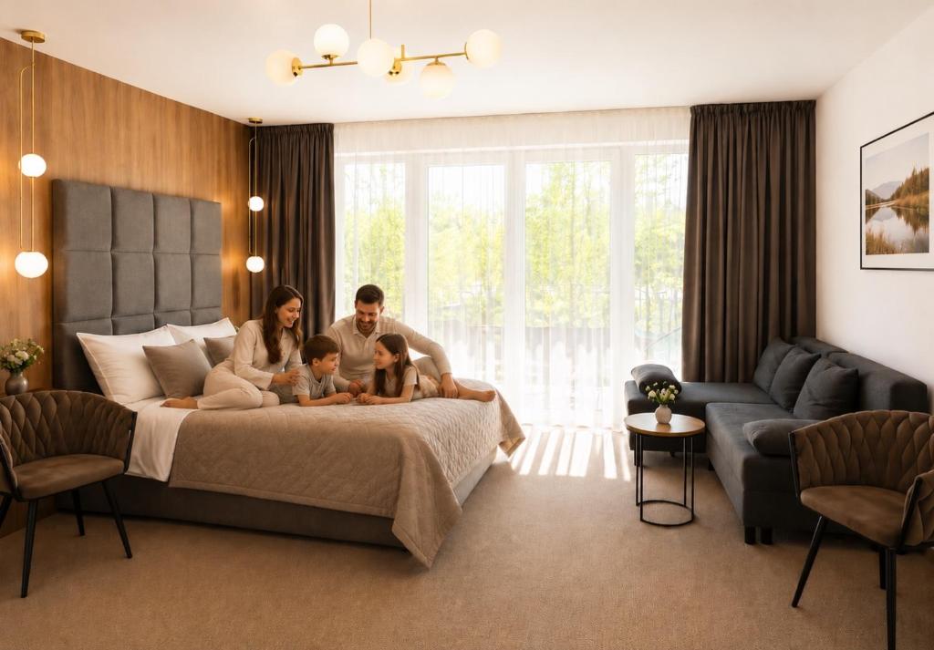 a family sitting on a bed in a bedroom at Eden Apartament Jakuzzi, sauna in Rozewie