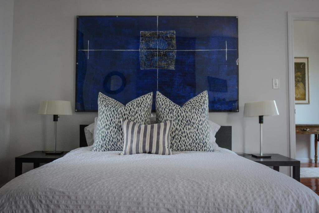 a bedroom with a bed with a blue painting on the wall at Casa Hudson in Haverstraw