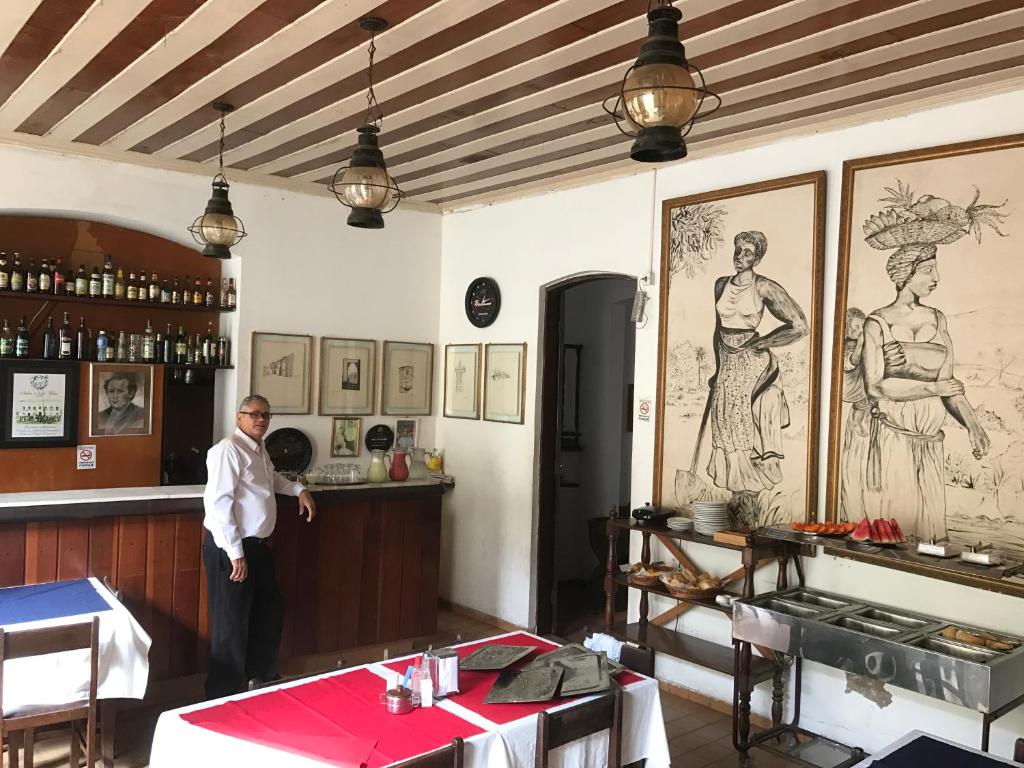 Ein Mann steht in einem Zimmer mit Bar. in der Unterkunft Pousada Colonial Penedo - Alagoas in Penedo