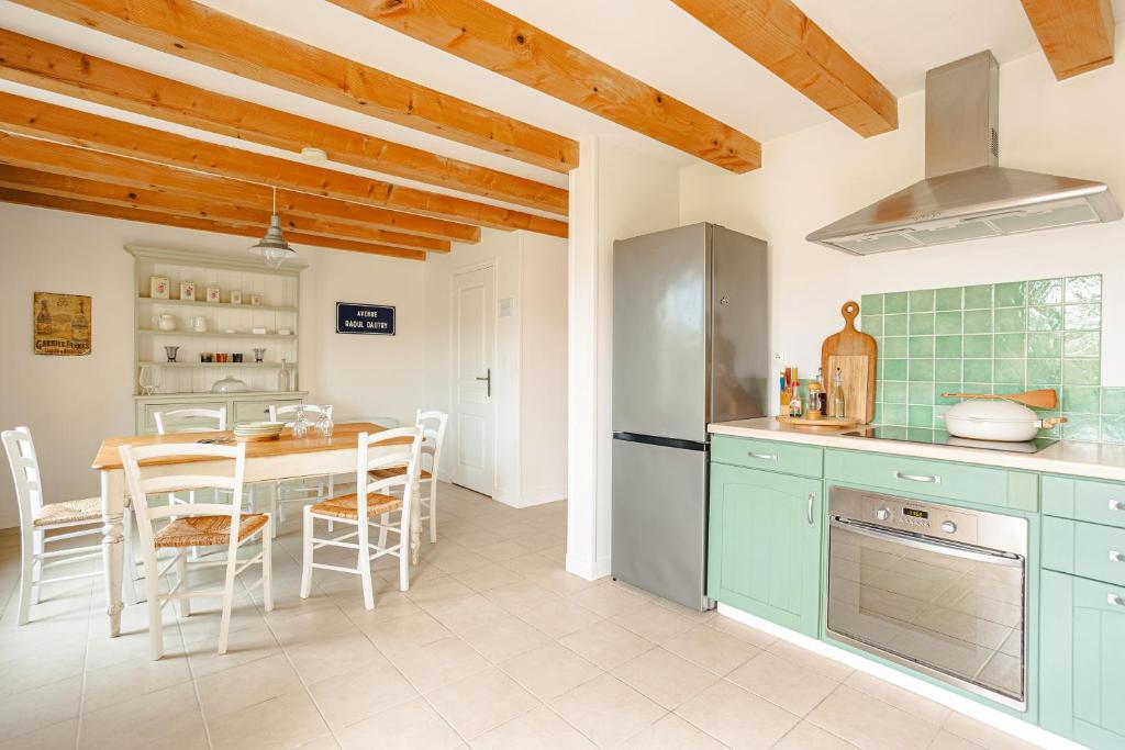 a kitchen with blue cabinets and a table with chairs at Opaline à la Rochelle in Vergné