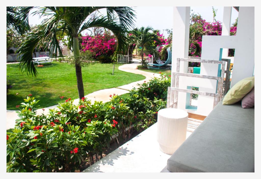 a balcony with a palm tree and a garden with flowers at Phan rang kite center in Ấp Mỹ Hải