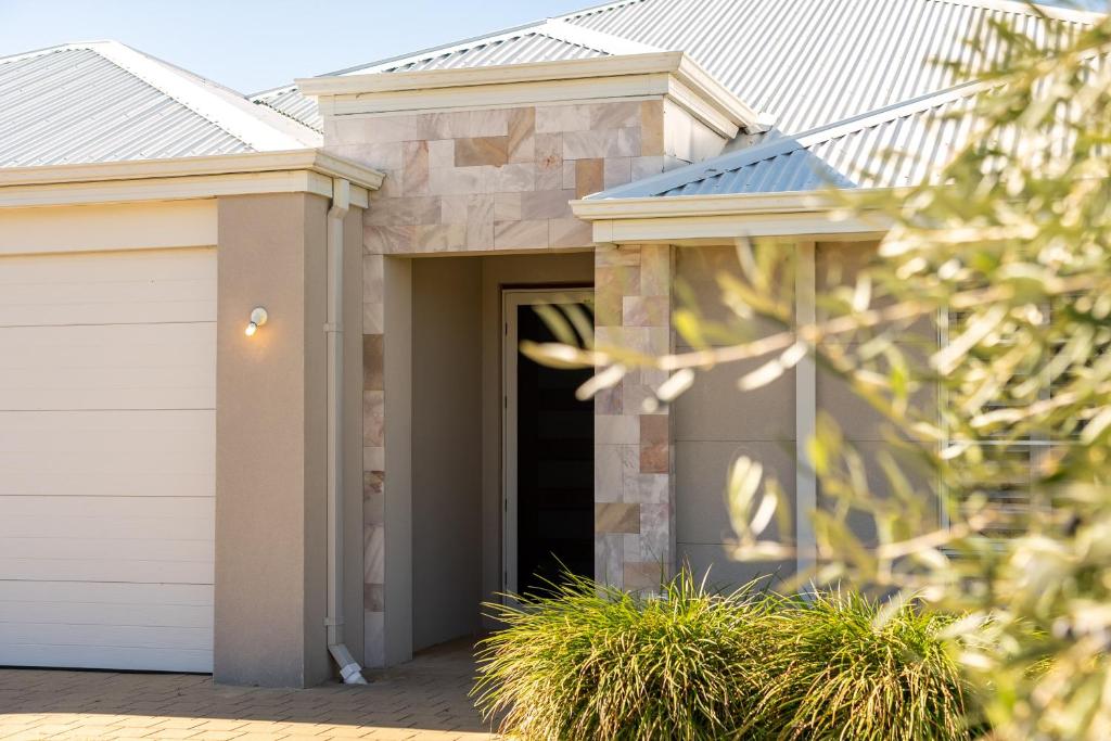 a house with a garage and a black door at Garrison Cottage in The Vines