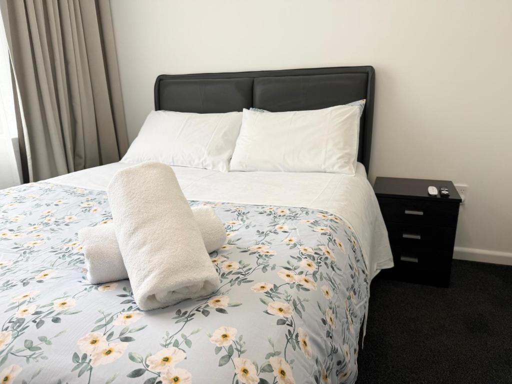 a bedroom with a bed with towels on it at Home Inn Timaru in Timaru