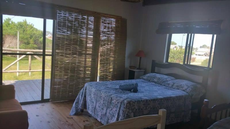 1 dormitorio con 1 cama con edredón azul en Diabluras, en Punta del Diablo