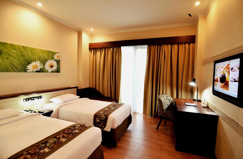 Postel nebo postele na pokoji v ubytování Angkasa Garden Hotel