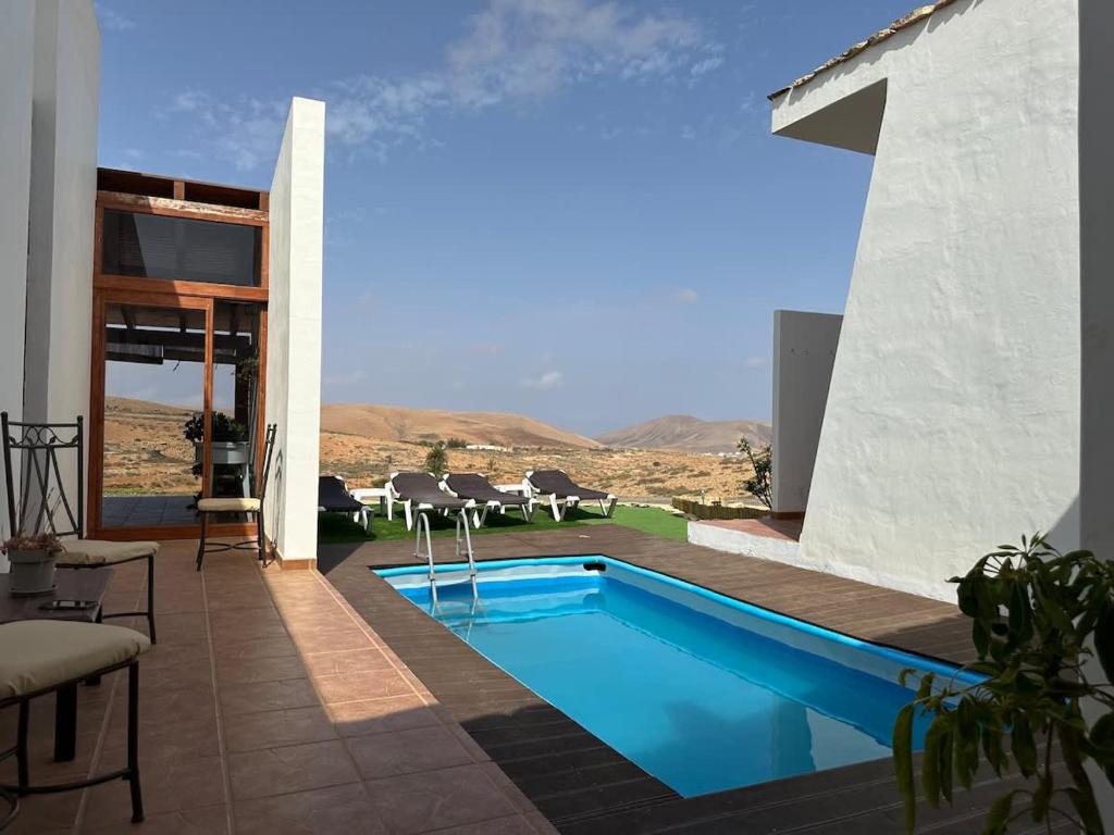 a pool in a house with a view of the desert at Private villa with pool in the mountains in Pájara