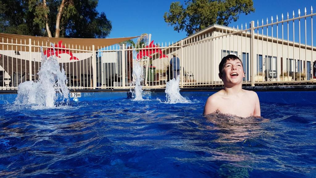 un joven en una piscina con fuentes de agua en Comfort Inn & Suites Augusta Westside, en Port Augusta