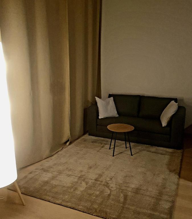 a living room with a couch and a table at Downtown studio, near railwaystation, with exercise facilities in Seinäjoki