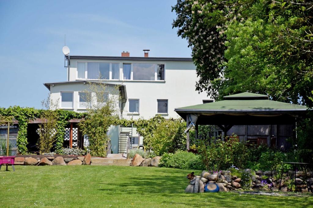 a house with a yard with a garden with a house at Ferienwohnung Altefaehr mit Seebli in Altefähr