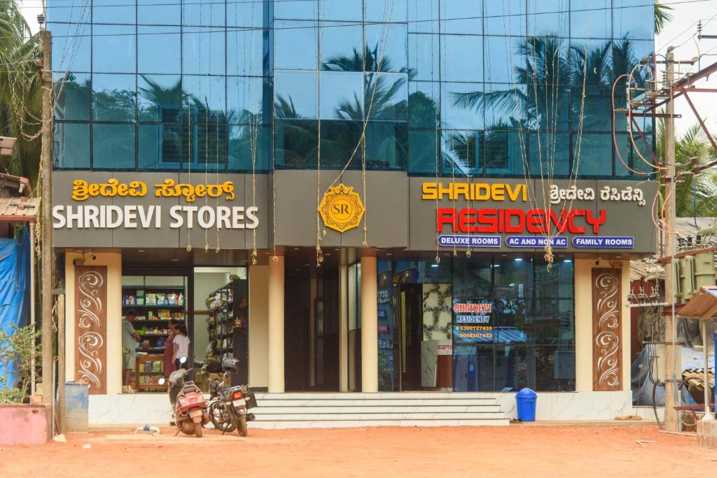a building with a motorcycle parked in front of it at Shridevi Residency in Honāvar