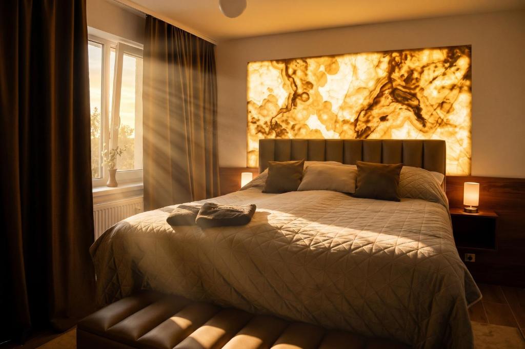 a bedroom with a bed with a painting on the wall at ADELA VIP Nezábudka - Tiché krídlo, 45m2 a TOP spánok in Tatranska Strba