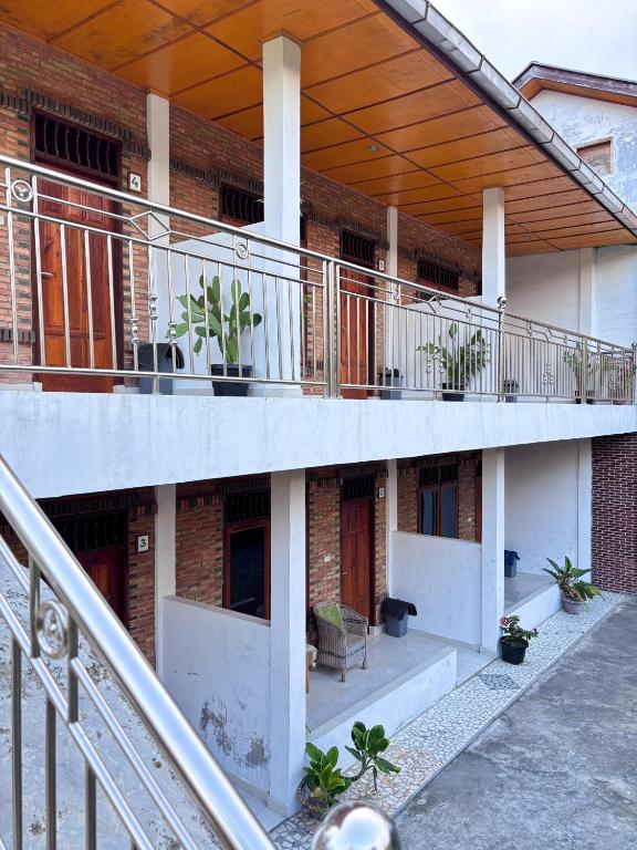 a building with a balcony with plants on it at Toba Boi in Tuktuk Siadong