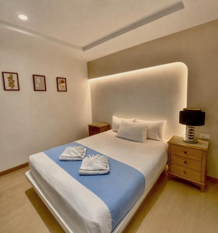a bedroom with a bed with two towels on it at Yukata Space in Sathani Nakhon Si Thammarat