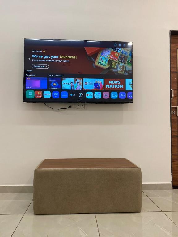 a flat screen tv hanging on a wall at KD Homes - Elite studio stay in Surat