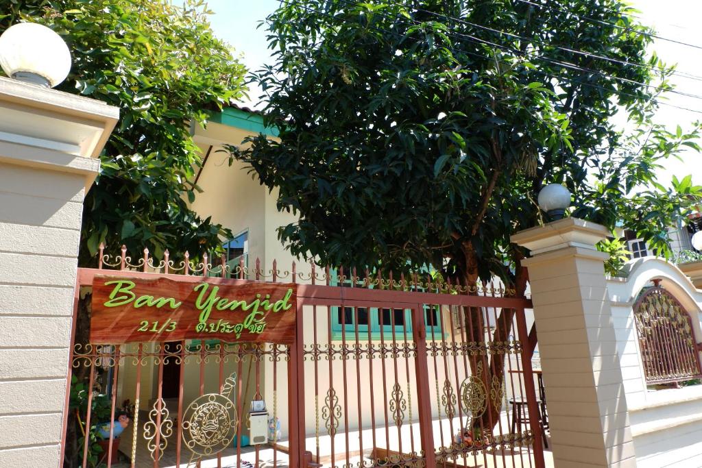 a fence with a sign on it next to a tree at Ban Yenjid in Phra Nakhon Si Ayutthaya