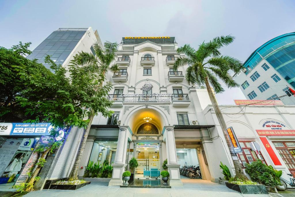a white building with a palm tree in front of it at Tan Son Nhat Airport - Golden Sun Hotel in Ho Chi Minh City