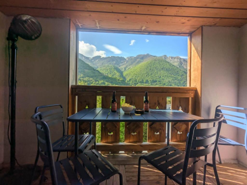 a table with two chairs and a window with mountains at Cauterets Mountain Nest in Cauterets