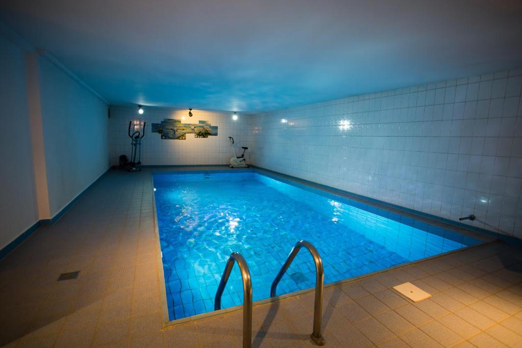 a large swimming pool with blue lights in a room at Hotel Am Sportpark in Duisburg