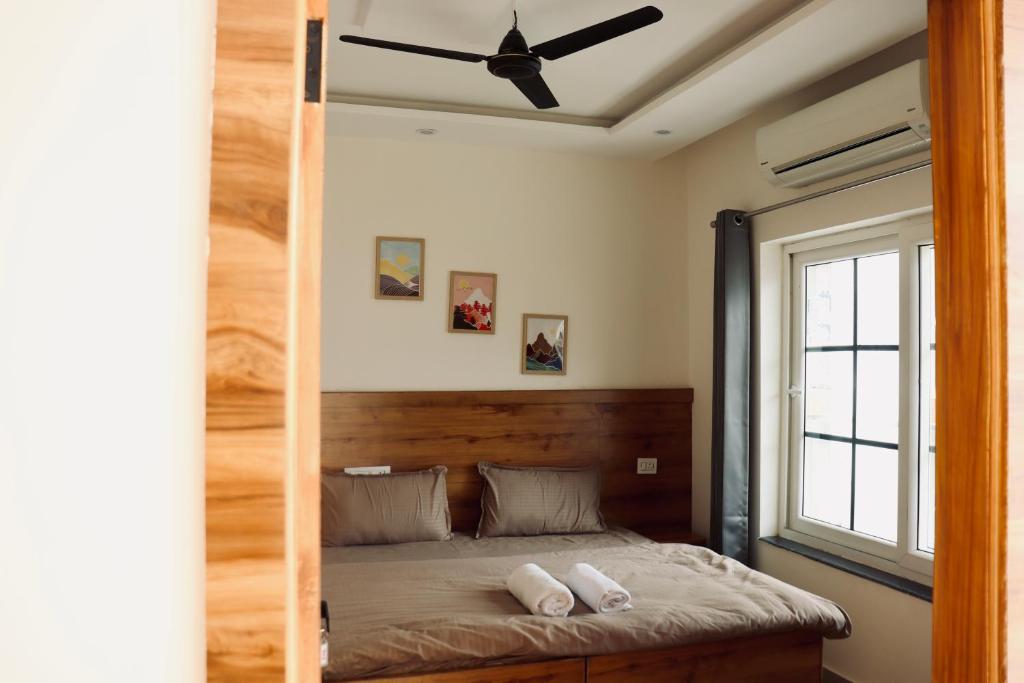 a bedroom with a bed with a ceiling fan at Aarunya Stays in Rishīkesh