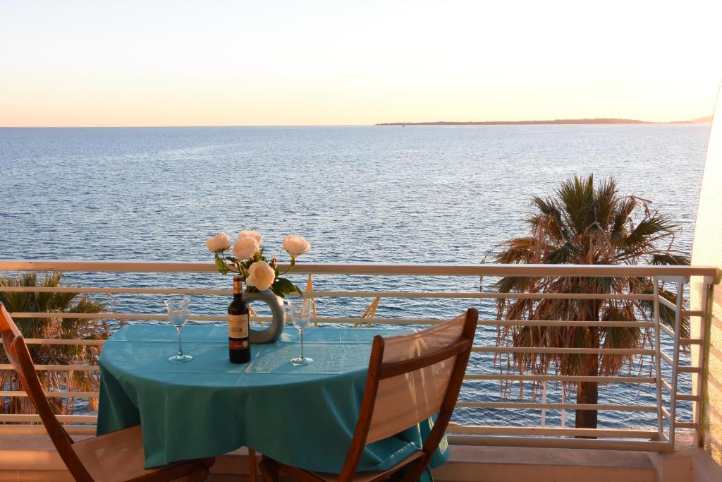 a table on a balcony with a view of the ocean at Résidence Le Soleil in Juan-les-Pins