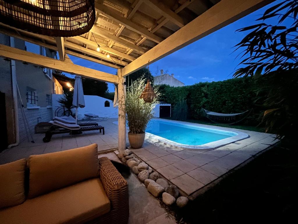 a patio with a couch and a swimming pool at Le Gecko in Saint-Victor-la-Coste