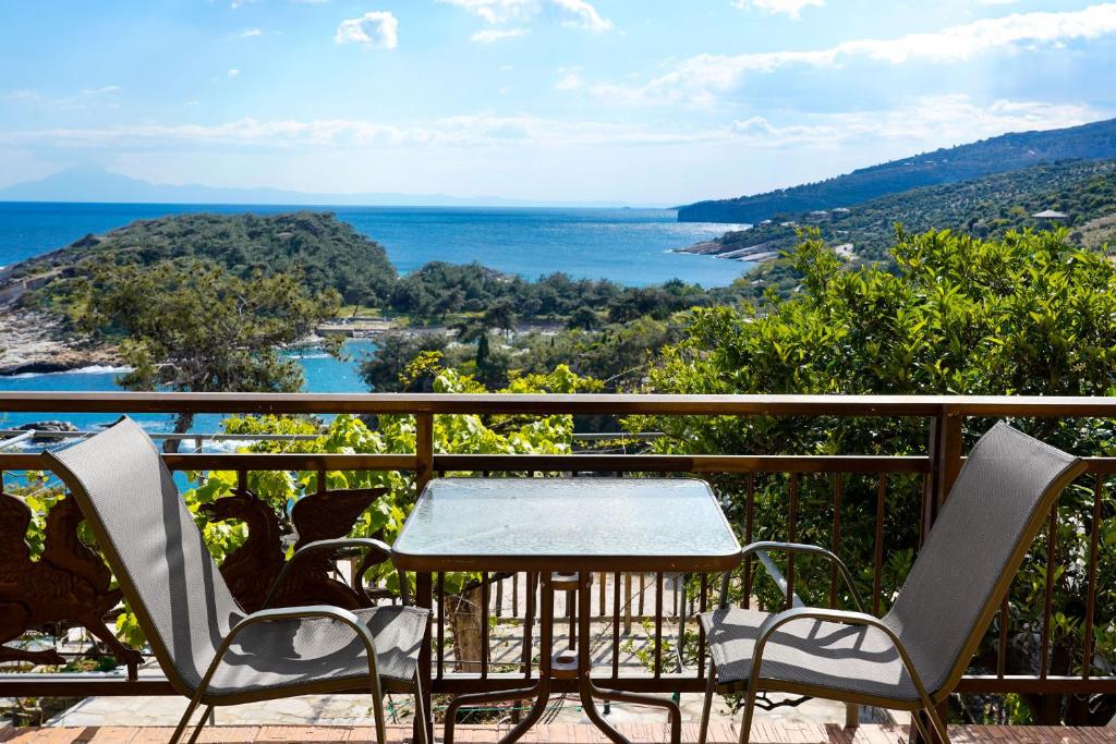 a table and chairs on a balcony overlooking the water at Archodissa Pansion in Alyki