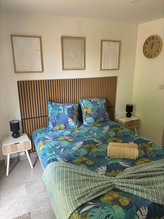a bedroom with two beds and a clock on the wall at Studio proche PARIS-orly in Sainte-Geneviève-des-Bois