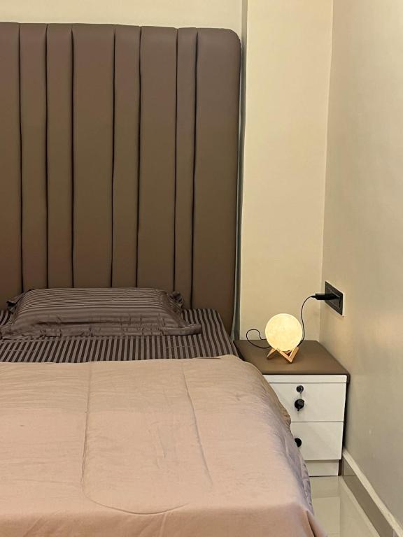 a bedroom with a bed and a lamp on a nightstand at KD Homes in Surat