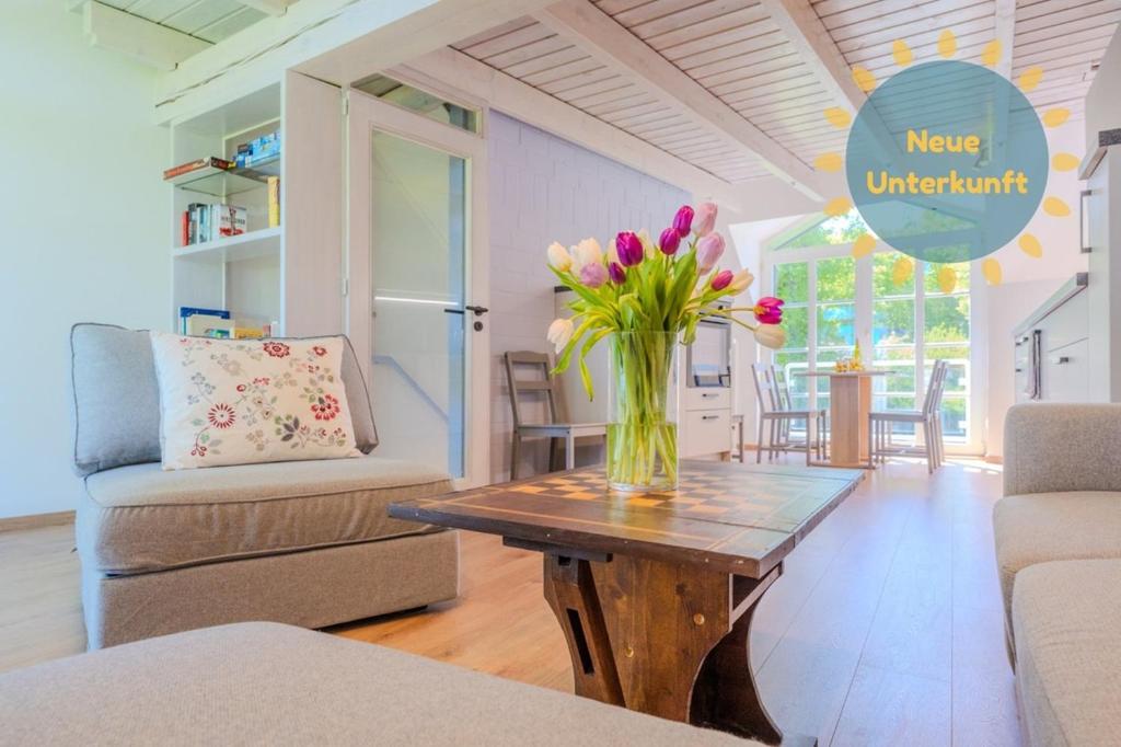 a vase of flowers on a wooden table in a living room at Ferienwohnung Stöfs in Behrensdorf