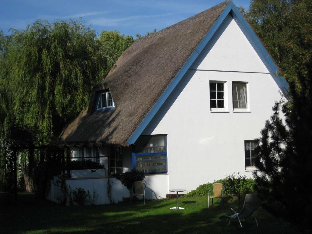 a white house with a thatched roof at Ferienhaus Sturm in Kloster