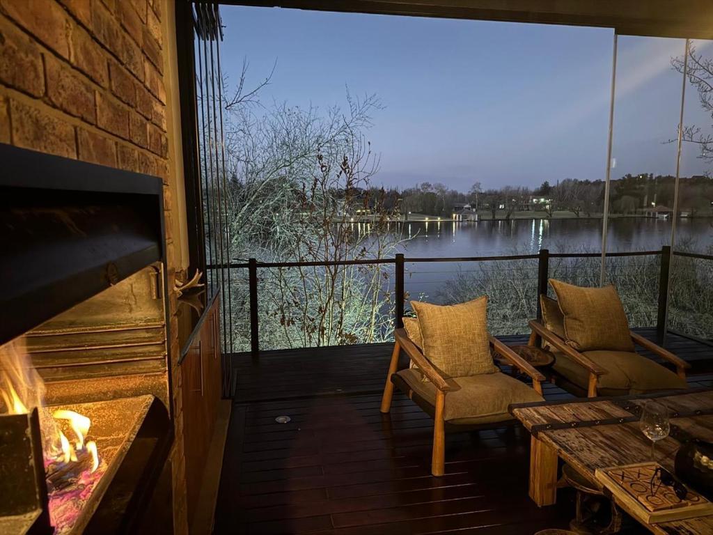 a screened in porch with two chairs and a fireplace at Vaal River Front Lodge in Sasolburg